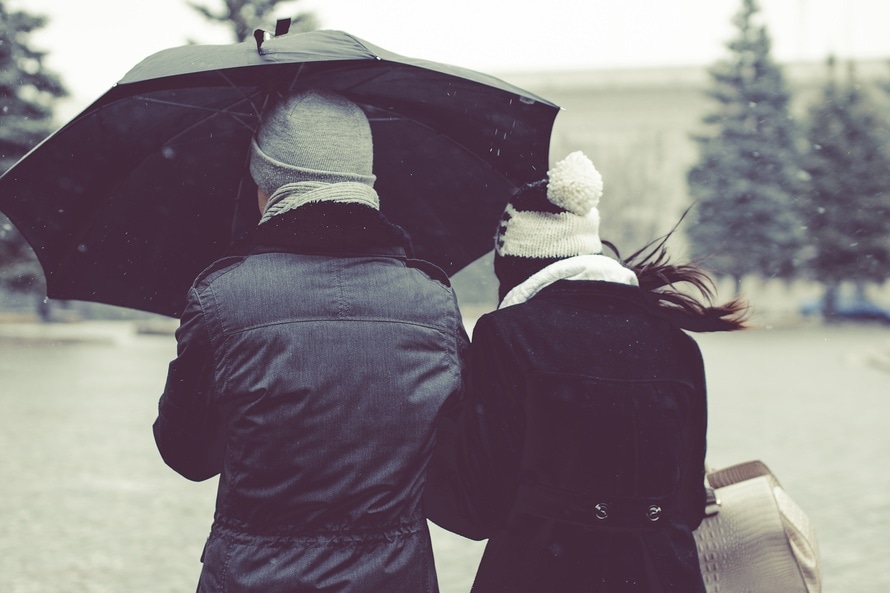 Para idzie pod parasolem w deszczowy dzień