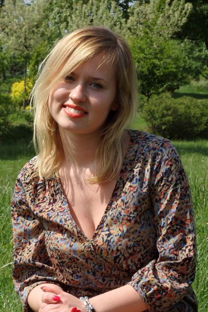 Kamila Czarnecka uśmiechająca się i siedząca na łące